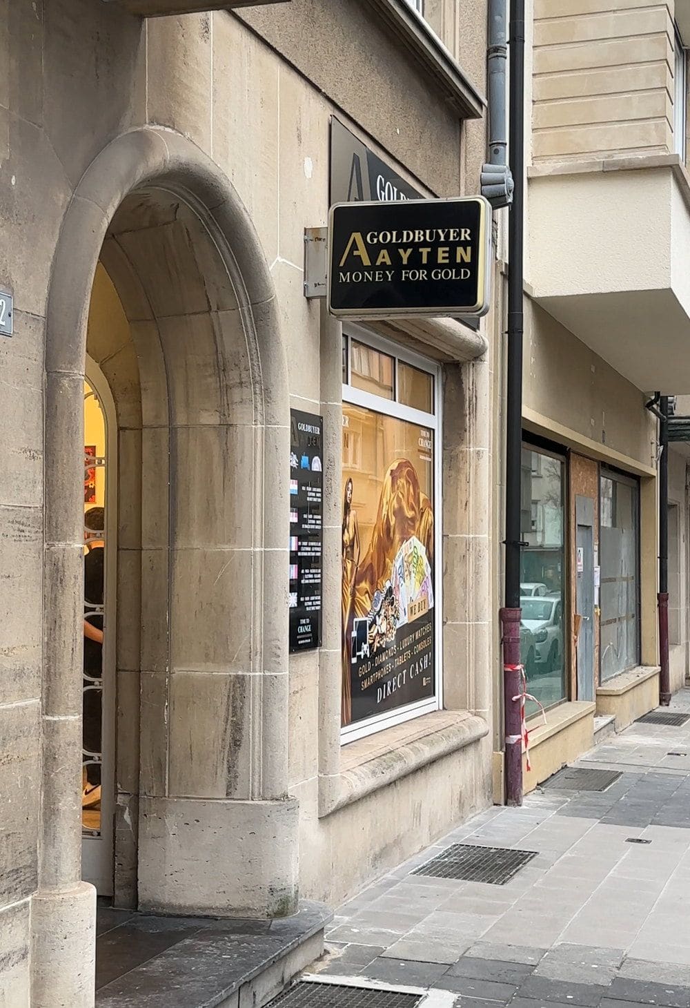 Eingang des Geschäfts Goldbuyer Ayten mit Sandsteinbogen und Schaufenster